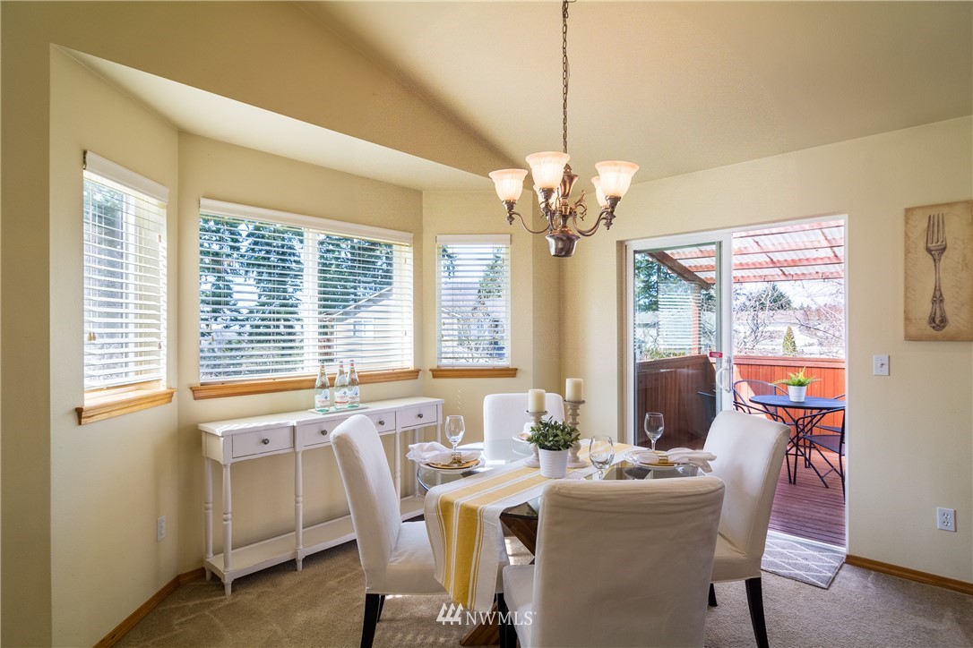7432 Upper Ridge Road Everett, WA 98203 - Photo 11 of 32 a view of a dining room with furniture a chandelier and wooden floor