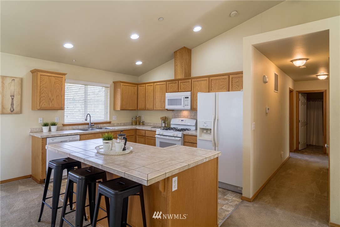 7432 Upper Ridge Road Everett, WA 98203 - Photo 8 of 32 a kitchen with a table chairs refrigerator and microwave