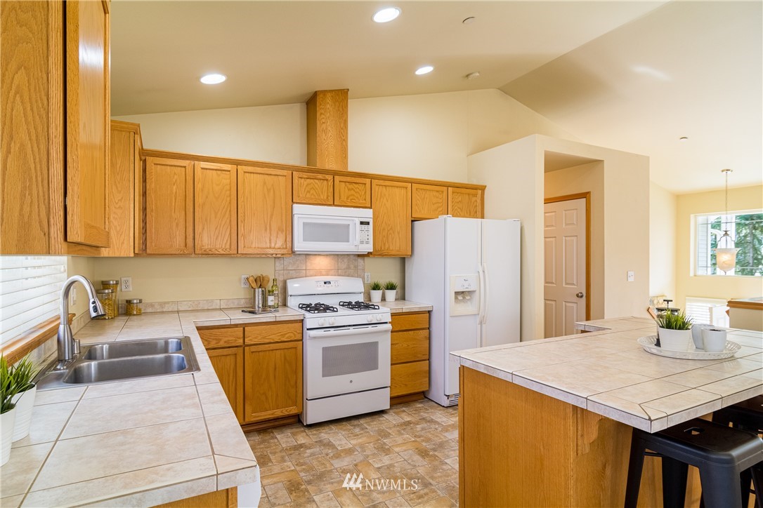 7432 Upper Ridge Road Everett, WA 98203 - Photo 9 of 32 a kitchen with stainless steel appliances a stove a sink a microwave a refrigerator and cabinets