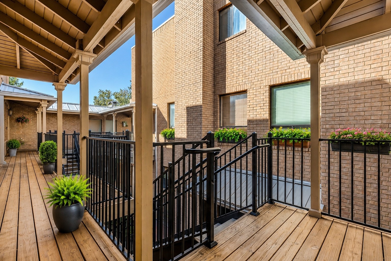 611 East 45th Street, Unit 25 Austin, TX 78751 - Photo 6 of 21 Covered outdoor walkway featuring wood-finish flooring, exposed beam ceiling, and architectural columns