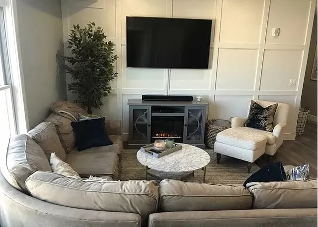 a living room with furniture a fireplace and a flat screen tv