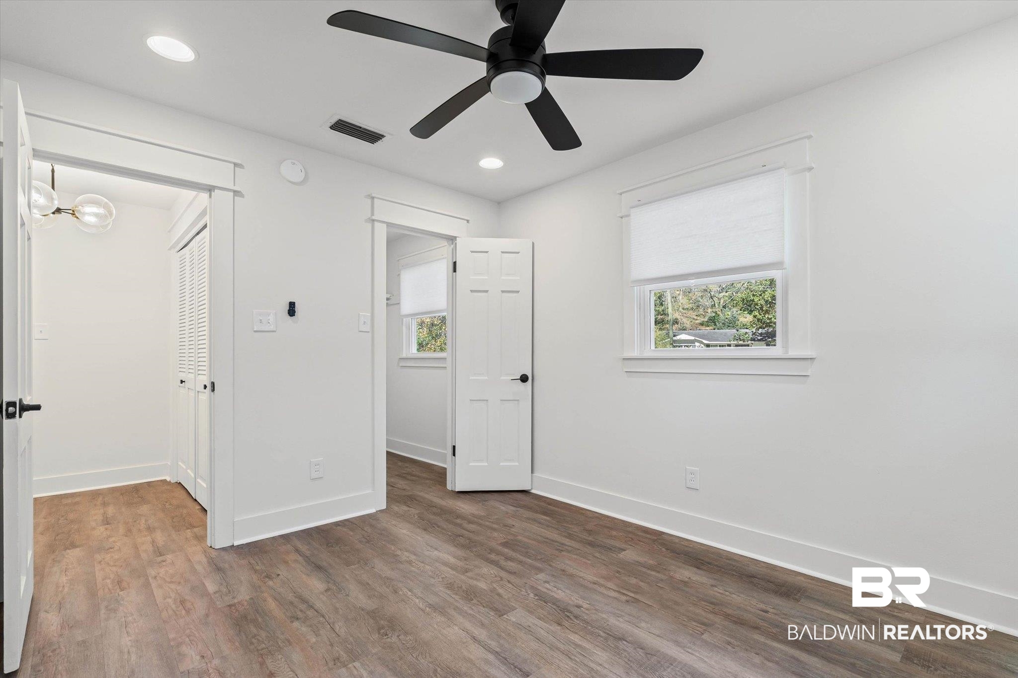 3933 Radnor Avenue Mobile, AL 36608 - Photo 22 of 36 Front bedroom with wood finished floors, recessed lighting, and a ceiling fan .. This Bedroom also has a walk-in closet. The hallway shows a peak of the louvered doors for the double hallway closet.