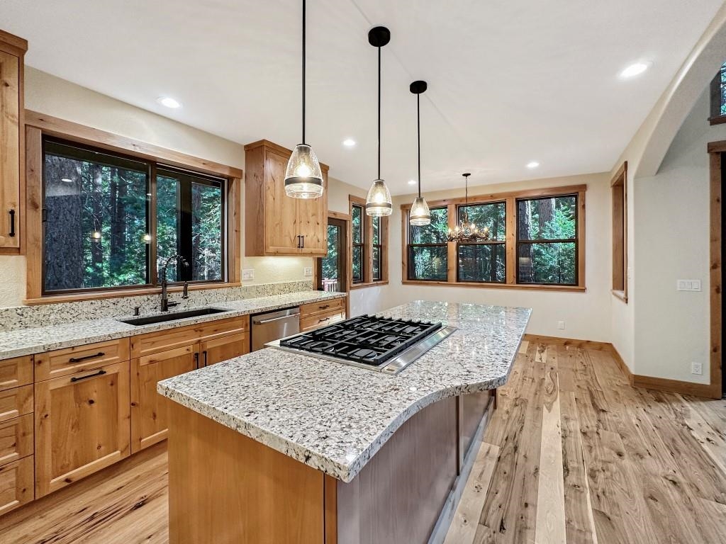 1025 Carmichael Road Clio, CA 96106 - Photo 5 of 21 a kitchen with stainless steel appliances granite countertop a stove a sink dishwasher and white cabinets with wooden floor