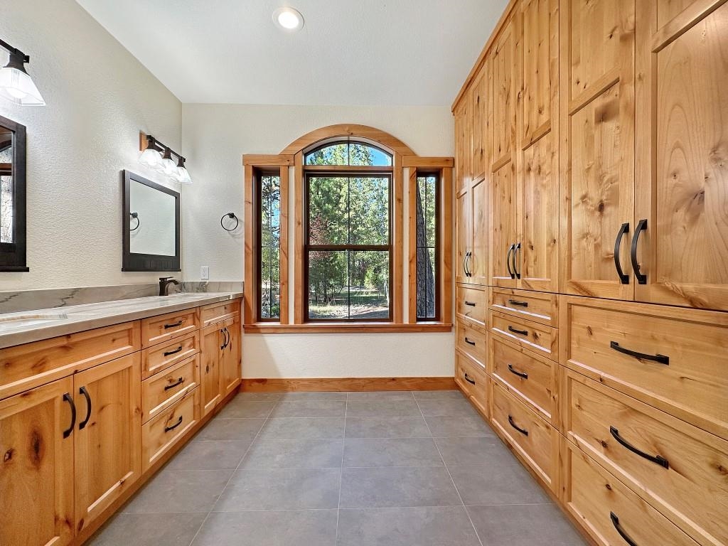 1025 Carmichael Road Clio, CA 96106 - Photo 10 of 21 a spacious bathroom with a double vanity sink a mirror and a bathtub next to a window