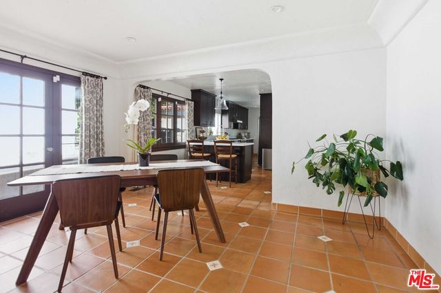 a dining hall with stainless steel appliances a table and chairs in it