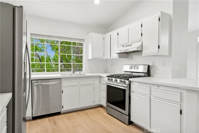 a kitchen with cabinets appliances and a window