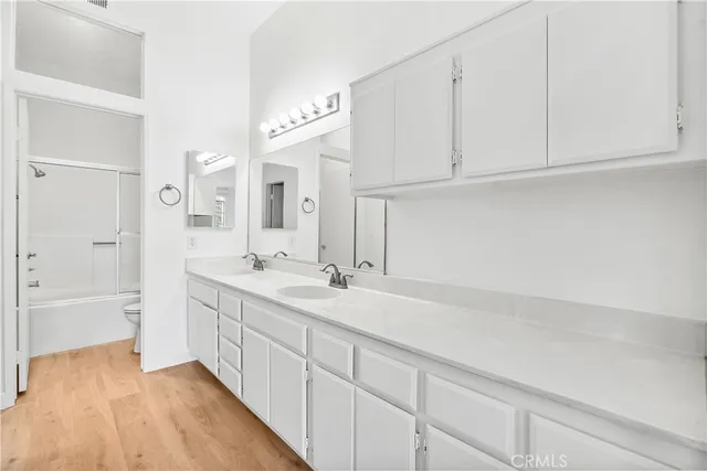 a spacious bathroom with a double vanity sink a mirror and a bathtub