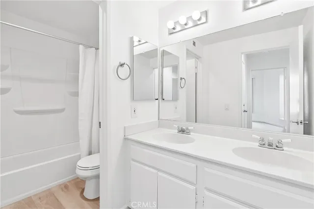 a bathroom with a sink a toilet and a large mirror