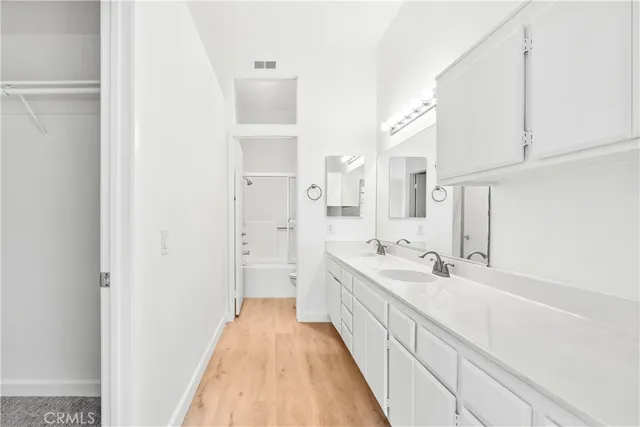 a spacious bathroom with a double vanity sink and mirror