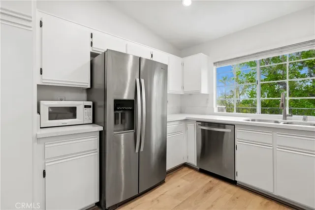 a kitchen with stainless steel appliances a refrigerator sink and microwave