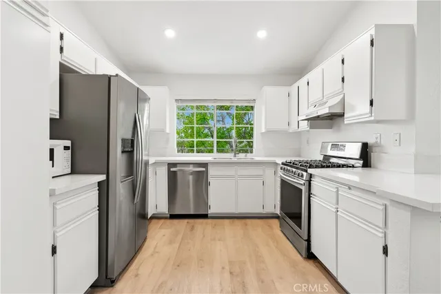 a kitchen with a sink stove and refrigerator