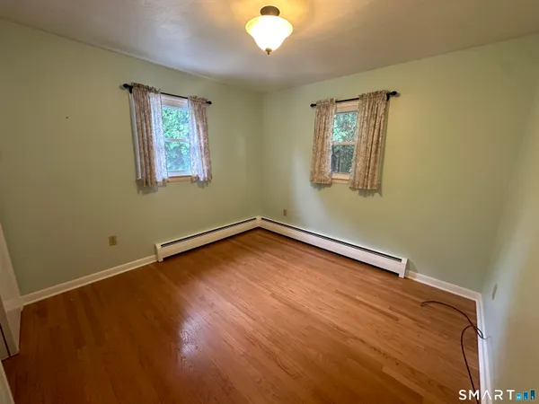 a view of a room with wooden floor and window