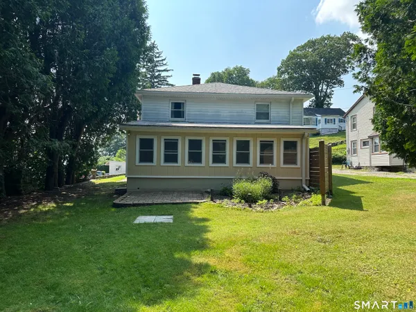 a view of a house with a yard and sitting area