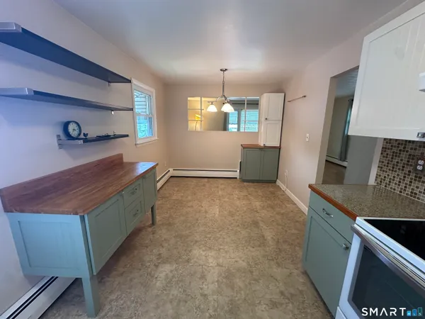 a room with kitchen island a sink a stove and a window