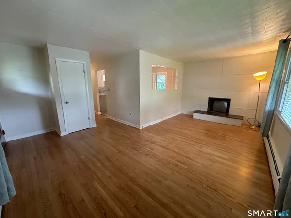 a view of a livingroom with wooden floor and a window