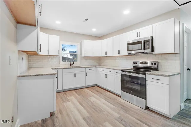 a kitchen with a sink a stove and cabinets