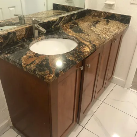 a bathroom with a granite countertop sink and a mirror