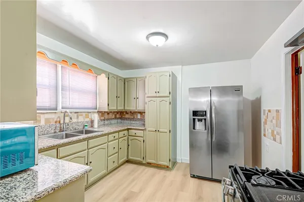 a kitchen with stainless steel appliances a refrigerator sink and cabinets