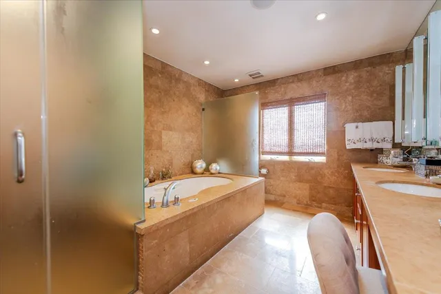 a bathroom with a tub sink and mirror