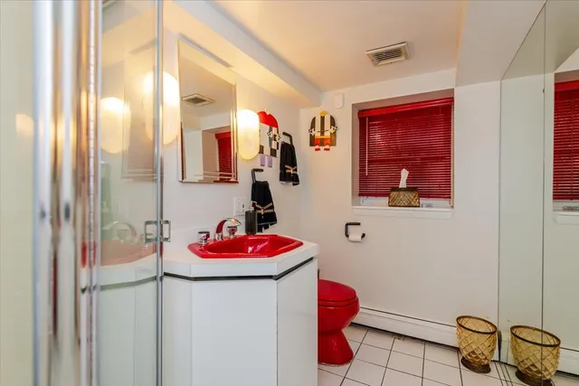 a bathroom with a sink and mirror with toilet