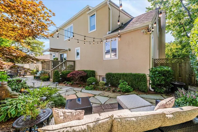 a view of backyard of house with outdoor seating and green space