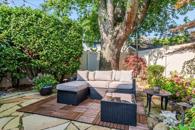 a view of a couches in the patio with a small yard