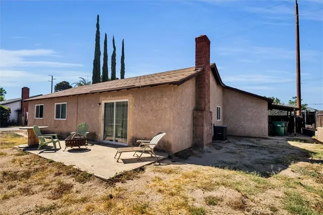 a backyard of a house with table and chairs