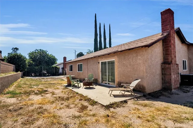 a backyard of a house with table and chairs
