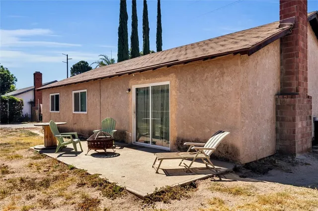 a backyard of a house with table and chairs