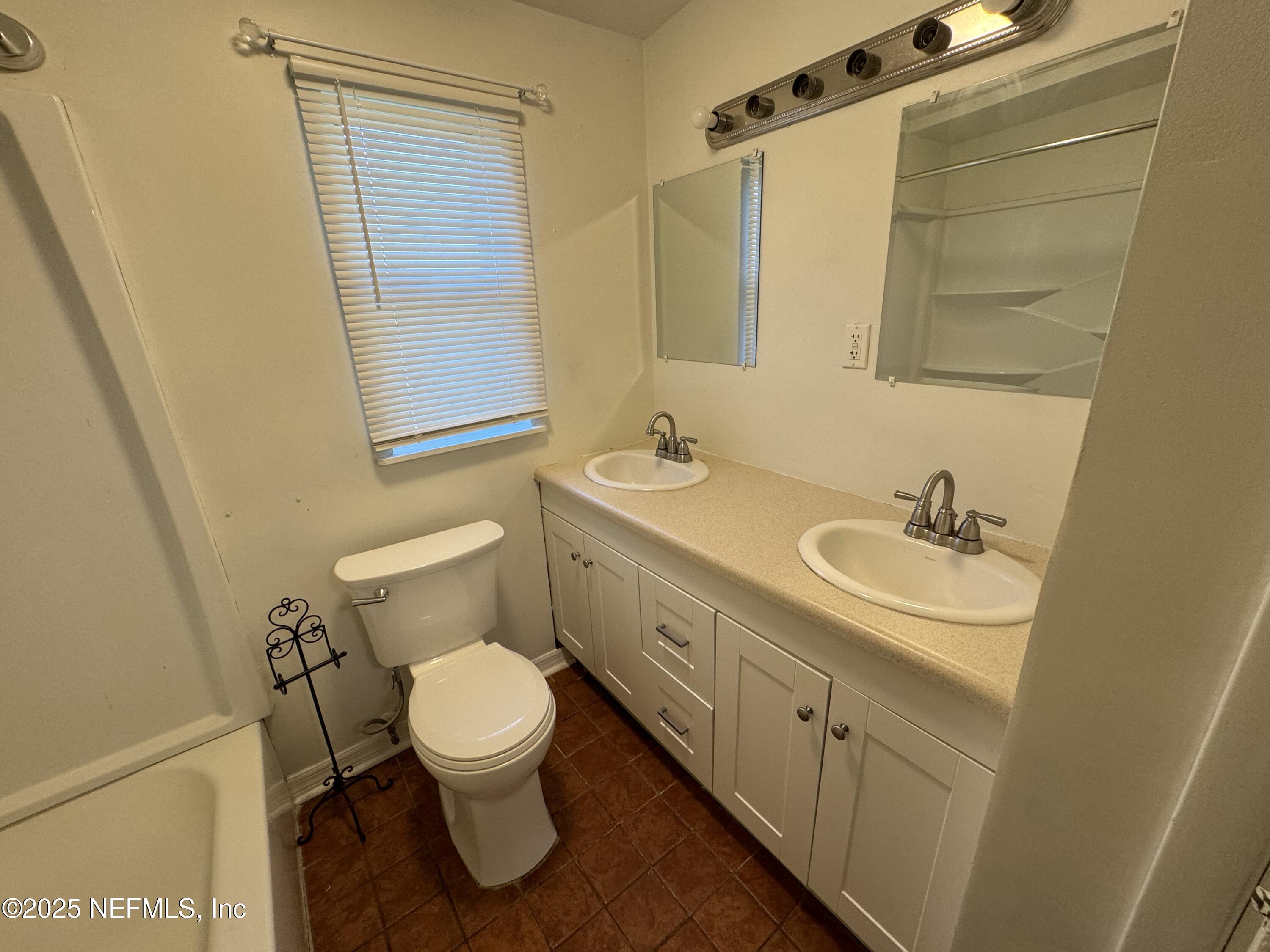 9359 Orme Road Jacksonville, FL 32220 - Photo 8 of 9 a bathroom with a granite countertop toilet sink and a mirror