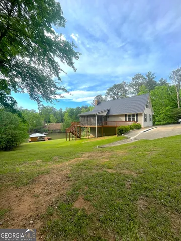 a view of a big house with a big yard and large trees