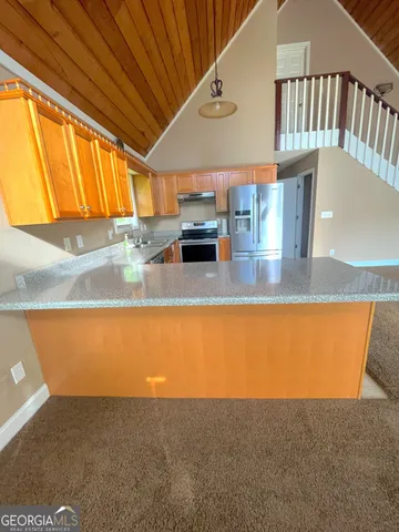 a view of kitchen with kitchen island a sink and a counter top space