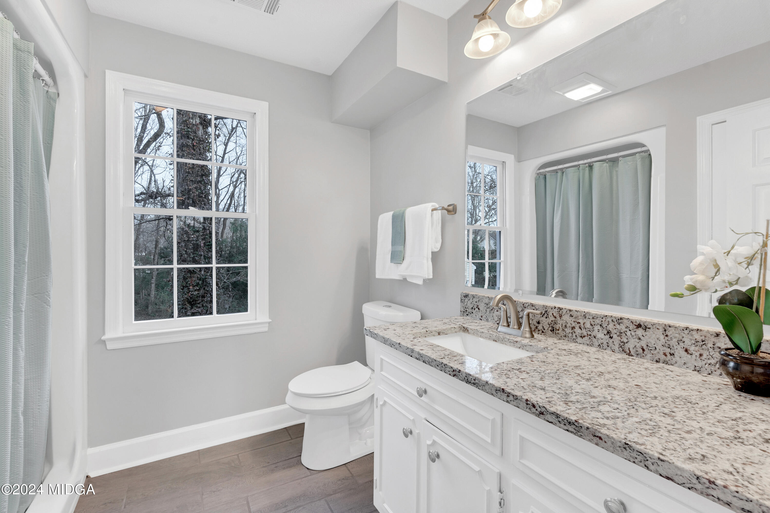 401 Stone Edge Road Macon, GA 31210 - Photo 44 of 69 a bathroom with a granite countertop sink toilet and large mirror