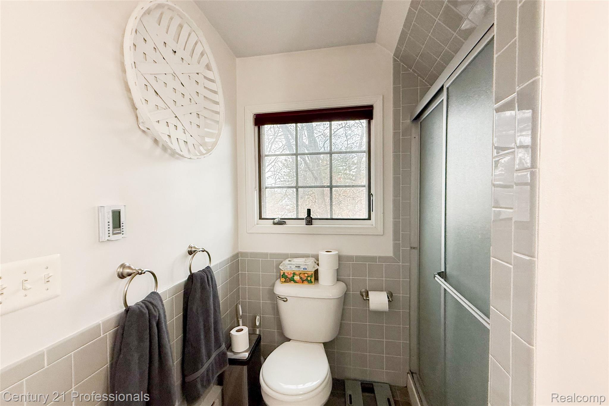 910 West Pine Tree Road West Lake Orion, MI 48362 - Photo 41 of 52 Bathroom featuring tile walls, a wainscoted wall, and a shower stall