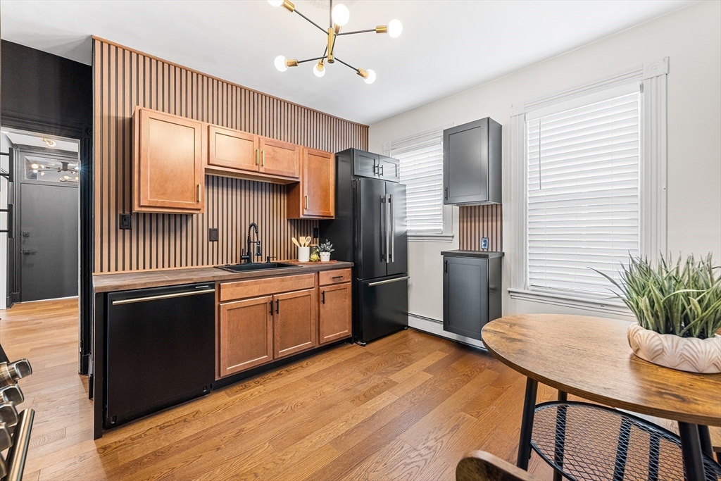 8 Spring Garden Street, Unit 3 Boston, MA 02125 - Photo 16 of 37 a kitchen with stainless steel appliances granite countertop a refrigerator a sink dishwasher a stove and white cabinets with wooden floor