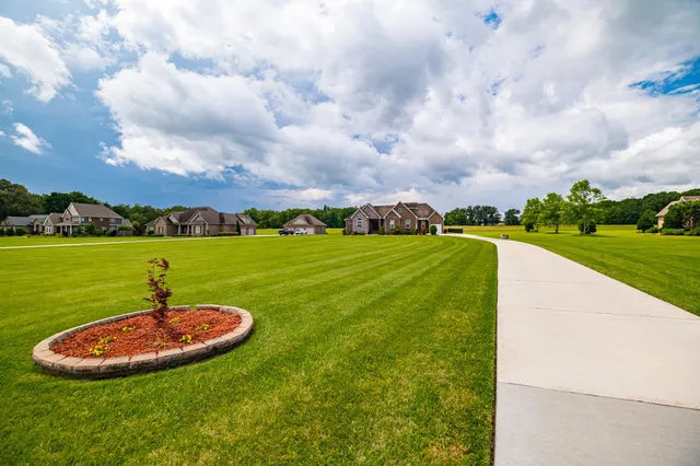 a swimming pool with a yard and green space