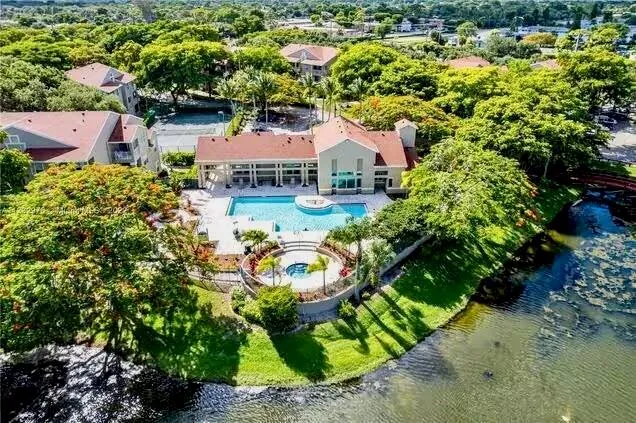 an aerial view of a house with a garden and lake view