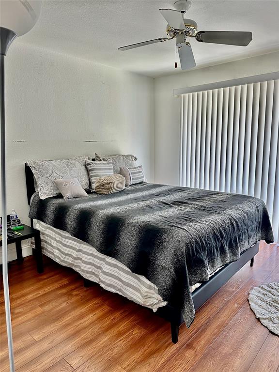 1780 Palm Cove Boulevard, Unit 6308 Delray Beach, FL 33445 - Photo 7 of 12 a bed sitting in a bedroom next to a window and wooden floor