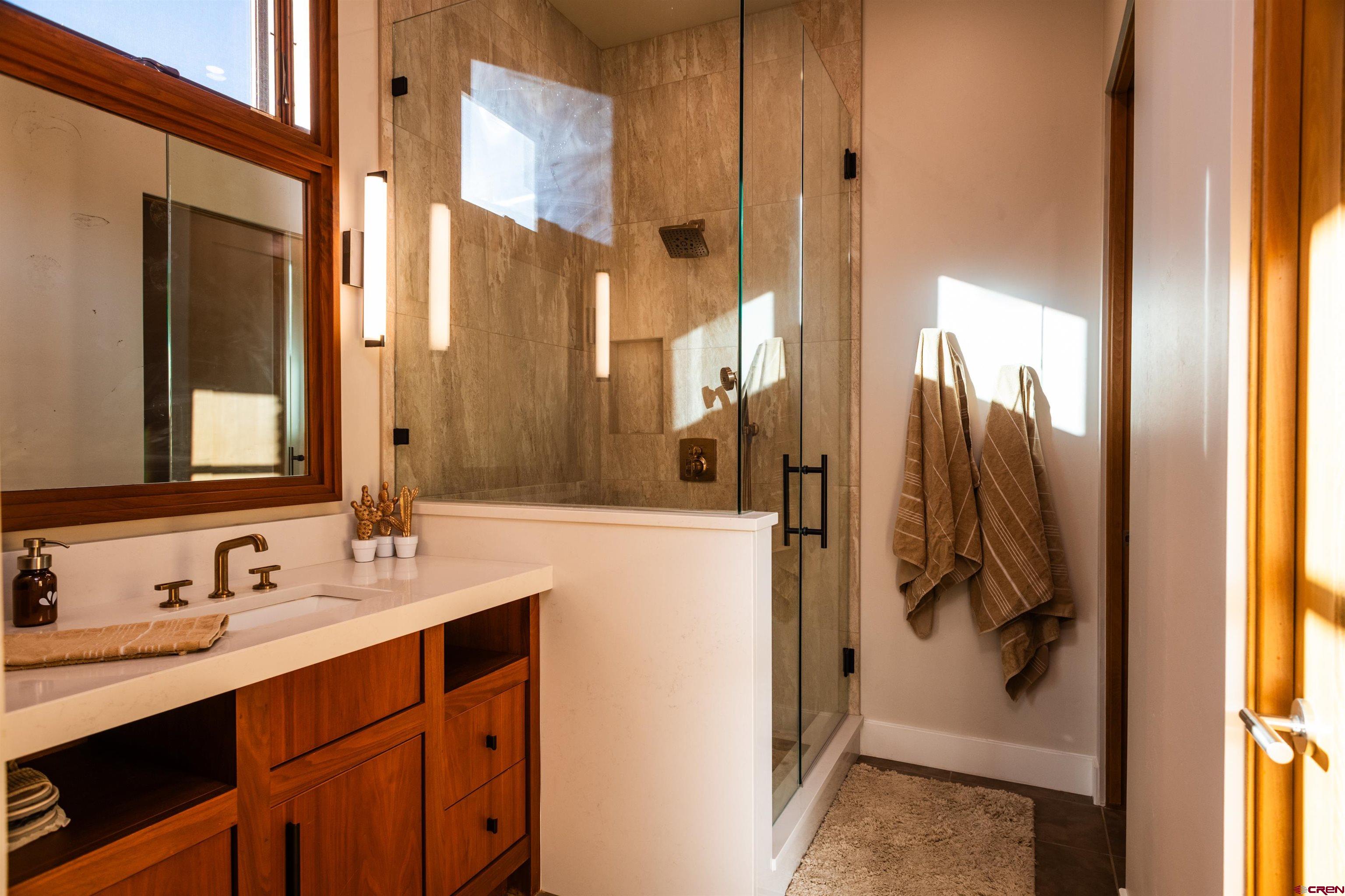 235 Rock Point Drive, Unit 235B Durango, CO 81301 - Photo 33 of 37 a bathroom with a double vanity sink mirror and shower