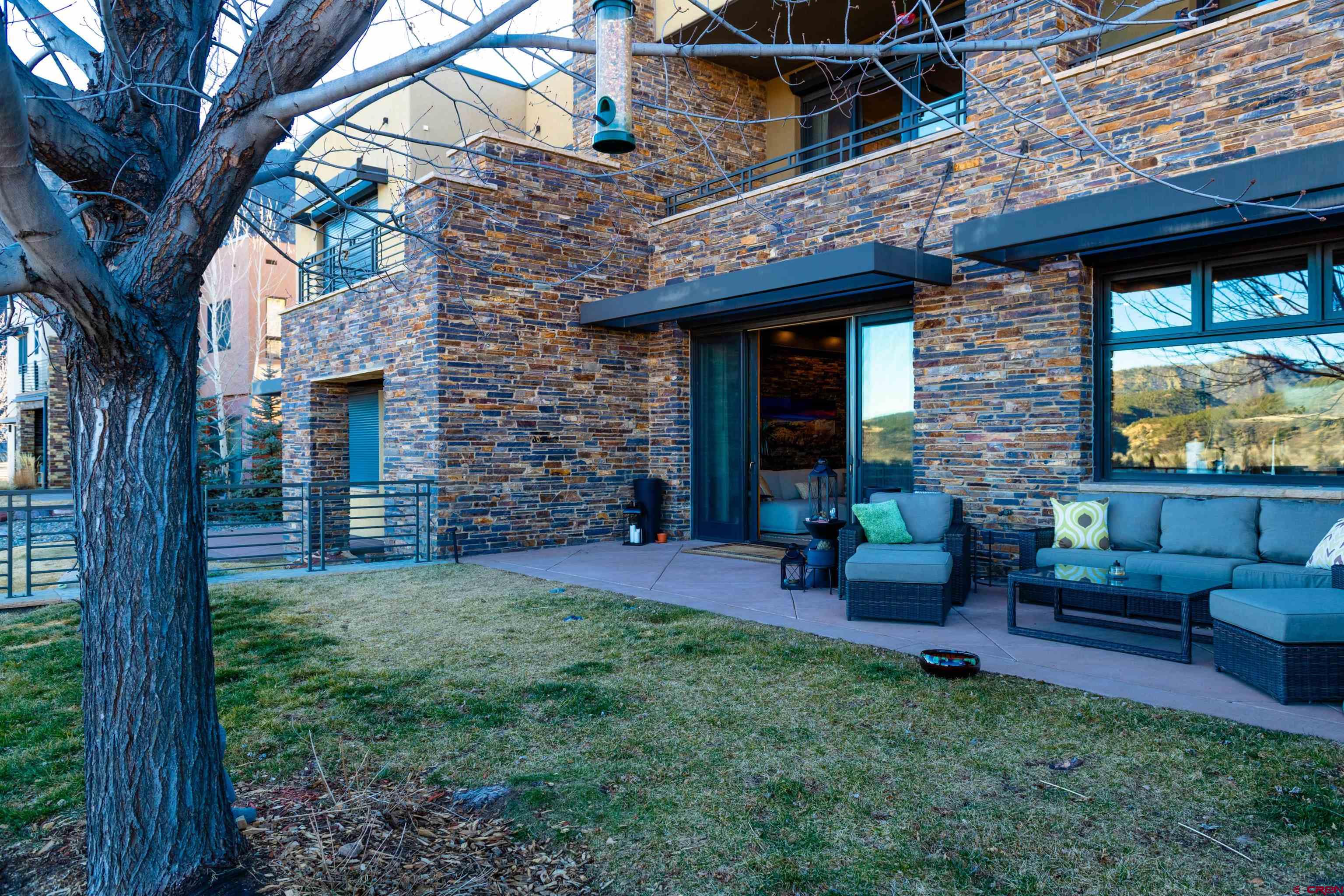235 Rock Point Drive, Unit 235B Durango, CO 81301 - Photo 4 of 37 a view of a brick house with a yard table and chairs