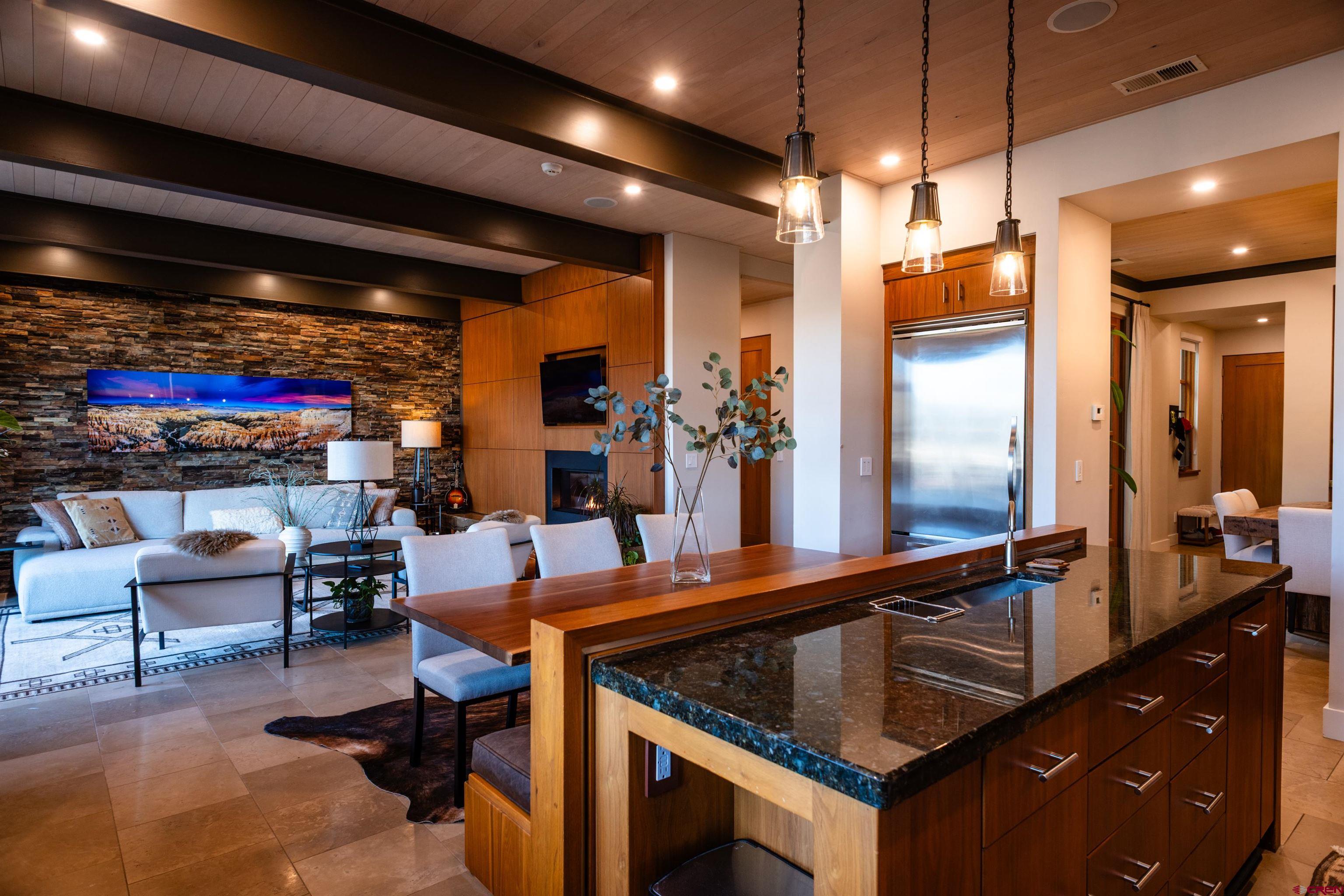 235 Rock Point Drive, Unit 235B Durango, CO 81301 - Photo 7 of 37 a kitchen with stainless steel appliances kitchen island granite countertop a table chairs and a refrigerator