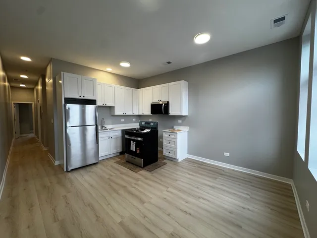 a kitchen with stainless steel appliances a refrigerator and a stove top oven