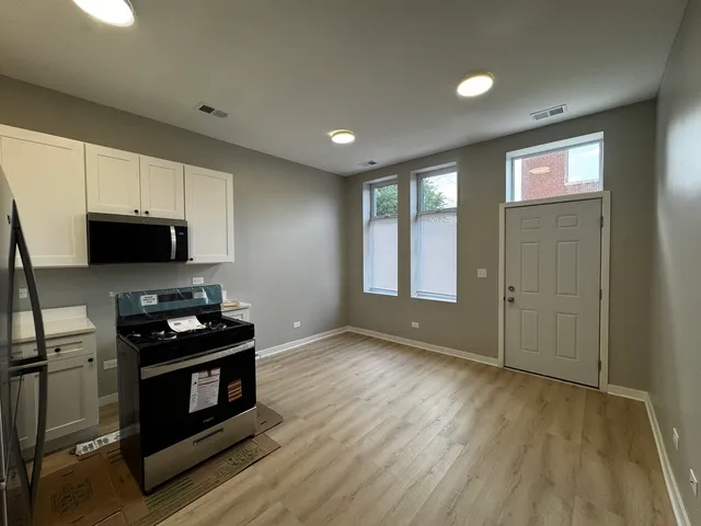 a kitchen with stainless steel appliances granite countertop a stove a sink and a microwave