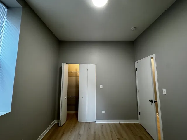 an empty room with wooden floor and closet