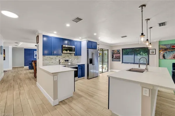 a kitchen with stainless steel appliances granite countertop a sink a stove a refrigerator and a oven