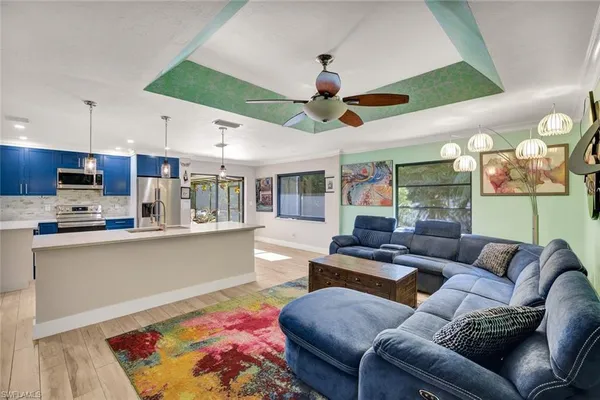 a living room with stainless steel appliances furniture and a large window