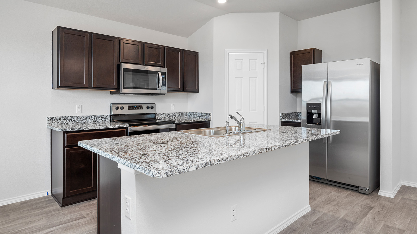 1418 Victory Rnch Trail Killeen, TX 76549 - Photo 6 of 22 Culinary delights await in this modern kitchen featuring rich cabinetry and a generous granite-topped island with a sink.