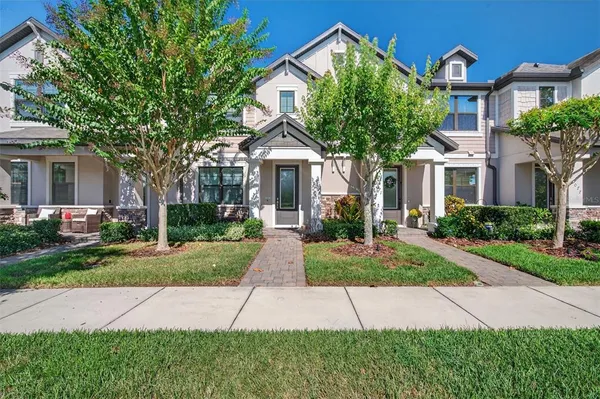 a front view of a house with a yard and trees