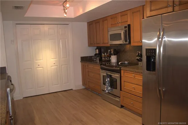 a kitchen with stainless steel appliances granite countertop a refrigerator and a stove top oven