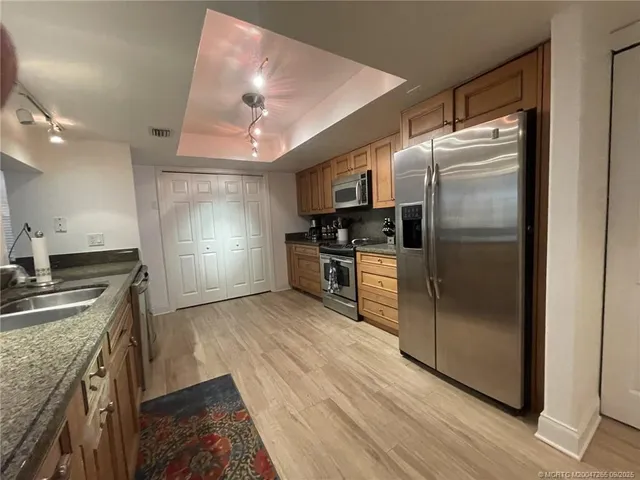 a kitchen with kitchen island a counter top space a sink and stainless steel appliances